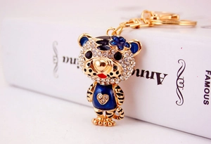 Gros plan d'un porte-clés tigre en émail bleu avec strass brillants sur un livre