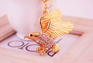 Detailaufnahme des goldenen Adler-Schlüsselanhängers mit glitzernden Strasssteinen