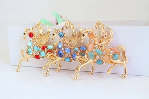 Détail des cristaux multicolores et des strass sur les pendentifs Pégase en métal doré