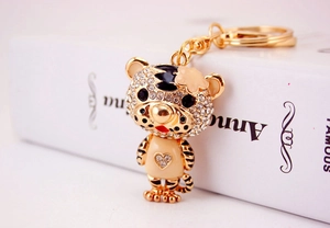 Détail d'un porte-clés tigre doré orné de strass brillants et d'une finition en émail beige