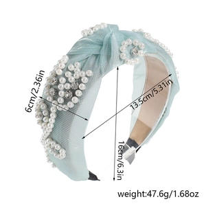 Detailed view of mint green mesh headband with faux pearls and size dimensions labels