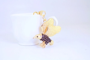 Nahaufnahme des goldenen Adler-Schlüsselanhängers mit schwarzen Strasssteinen