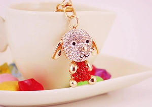 Détails d'un porte-clés chien doré orné de strass brillants blancs et rouges élégants