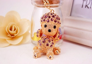 Close-up of golden poodle keychain with sparkling purple rhinestones and lobster clasp