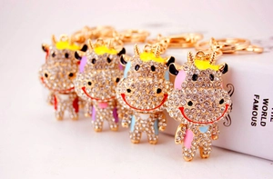 Détail macro de porte-clés vache en strass en options rose, bleu, violet et rouge