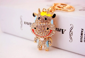 Détail macro du porte-clés vache dessin animé avec strass brillants et alliage doré poli