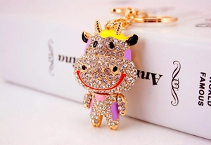 Détail d'un porte-clés vache dorée avec des strass étincelants et de l'émail coloré
