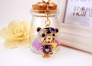 Détail du porte-clés tigre doré du zodiaque avec strass brillants et décor floral en émail violet