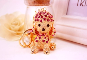 Detail of rose red crystal poodle keychain with gold base and white imitation pearls