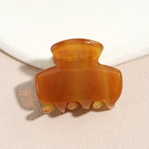 Detailed view of translucent amber resin hair claw with smooth finish and inner spring