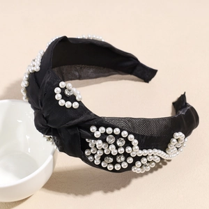 Detail of knotted black satin headband featuring embedded pearls and sparkling rhinestones