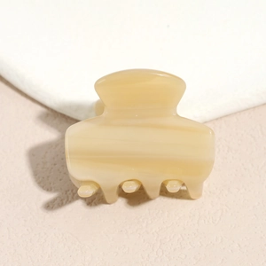 Close-up of small cream yellow acetate hair claw with elegant marble texture