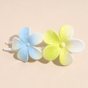 Détail de la pince à cheveux avec deux fleurs en dégradé et finition en résine polie