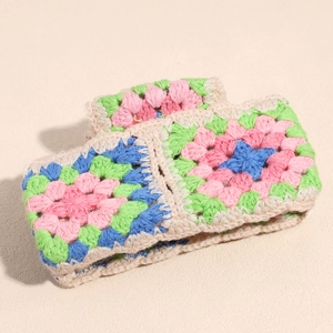 Close-up of handmade crochet hair claw clip with colorful granny square floral patterns