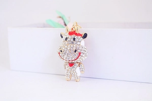 Détail d'un porte-clés vache mignon avec strass blancs et base en métal doré