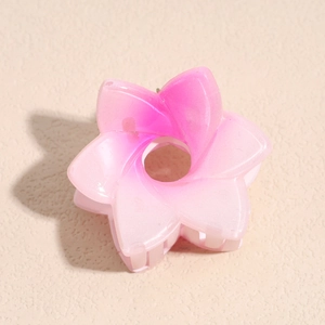 Détail d'une pince à cheveux en forme de fleur avec dégradé rose et fini translucide