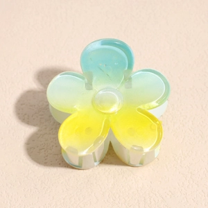 Close-up of frangipani hair claw clip with blue to yellow gradient finish