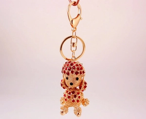 Detailed view of a golden poodle keychain featuring red rhinestones and a lobster clasp