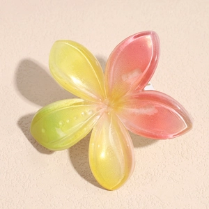 Dettaglio macro della molletta a fiore con sfumatura rosa e gialla e finitura perlata