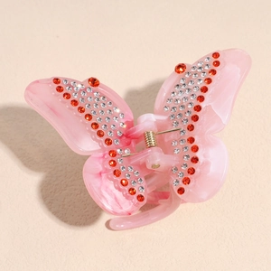 Close-up of pink butterfly hair claw with sparkling red and white rhinestones decoration