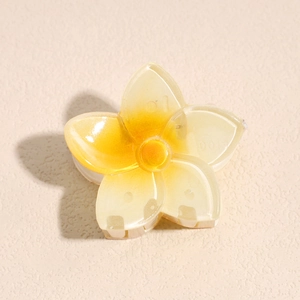 Gros plan d'une pince à cheveux fleur de 4cm jaune translucide avec détails de pétales