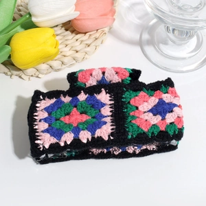 Detailed macro view of a colorful handmade crochet hair claw clip with granny square patterns