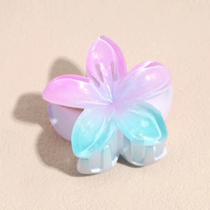 Detail of gradient pink-purple resin plumeria flower hair claw clip with multiple teeth