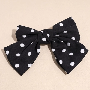 Detaillierte Nahaufnahme einer großen schwarz-weißen Haarklammer mit Polka-Dot-Muster