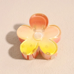 Detailed macro view of a yellow gradient frangipani hair claw with high-gloss finish