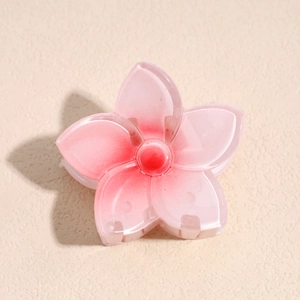 Détail rapproché de la pince à cheveux fleur dégradé rose avec pétales en résine