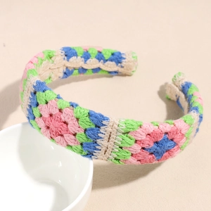 Detailed close-up of handmade floral crochet headband with colorful knitted yarn patterns