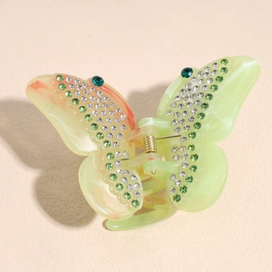 Detail of green butterfly hair claw clip with rhinestones and acetate texture
