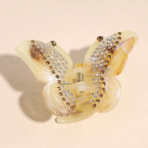 Detail of marble pattern butterfly hair claw clip with sparkling rhinestones and gold spring