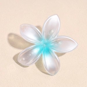 Detalle de la pinza para el pelo flor de frangipani con pétalos de resina azul