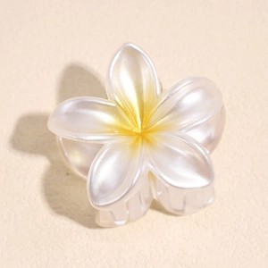 Close-up of small plumeria flower hair claw clip with pearlescent white and yellow finish