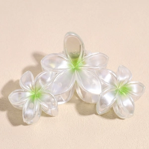 Détail macro de trois pinces à cheveux fleurs blanc nacré avec dégradés vert tendre