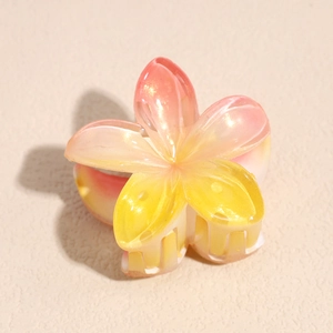 Macro view of gradient pink plumeria hair claw clip with pearlescent shimmer texture