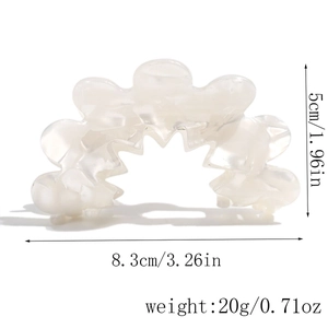 Detail view of acetate hair claw with marble texture and wavy edges including dimensions
