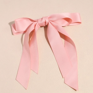 Dettaglio del fiocco in raso rosa con lunghi nastri eleganti e consistenza setosa