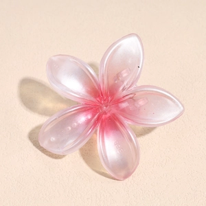 Detalle de la pinza para el pelo con flor rosa perlada y pétalos de resina translúcida
