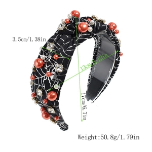 Detail view of Halloween headband with spider web pattern, orange pearls and rhinestones