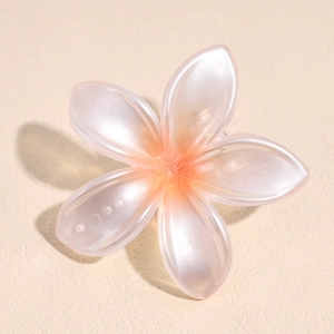 Detalle de la pinza de pelo de frangipani perlada con pétalos de resina en degradado naranja