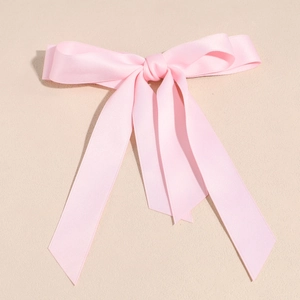 Dettaglio del fermaglio per capelli a fiocco in raso rosa pallido con nastri lunghi
