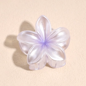 Detail of a pearlescent purple flower hair claw clip with subtle glitter finish