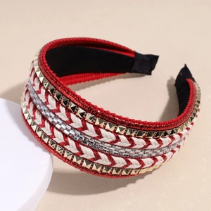 Close-up of woven red and white headband featuring gold pyramid studs and clear rhinestones