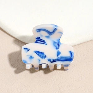 Detailed macro view of the small blue and white marble pattern acetate hair claw clip