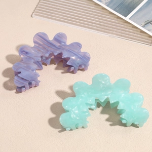 Acetate wavy flower hair claws in lavender and mint green marble texture on stone base