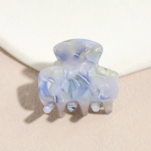 Detail of blue purple acetate hair claw with marble texture and five smooth teeth