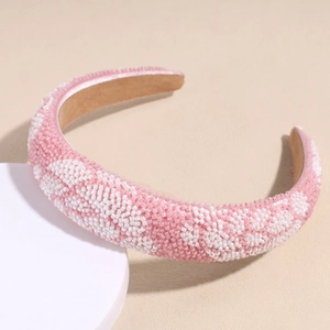 Close-up of pink and white beaded sponge headband with elegant floral textures