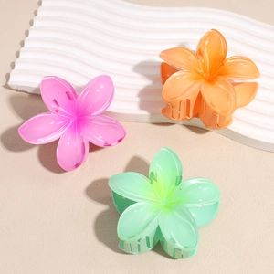 Three translucent colorful frangipani flower hair claws in pink orange and mint green